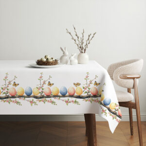 Aranżacja stołu ze świątecznym obrusem, koszykiem z dekoracjami i elegancką zastawą