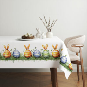 Aranżacja stołu z obrusm i prostą dekoracją: gniazdko z jajkami i wiosenne dodatki