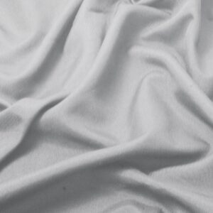 zbliżenie na gładką, lekko marszczoną fakturę jasnoszarego materiału obrusa