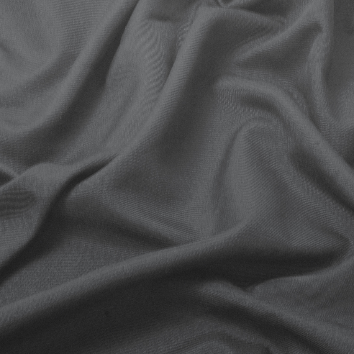 Zbliżenie na fakturę gładkiego, matowego materiału obrusa