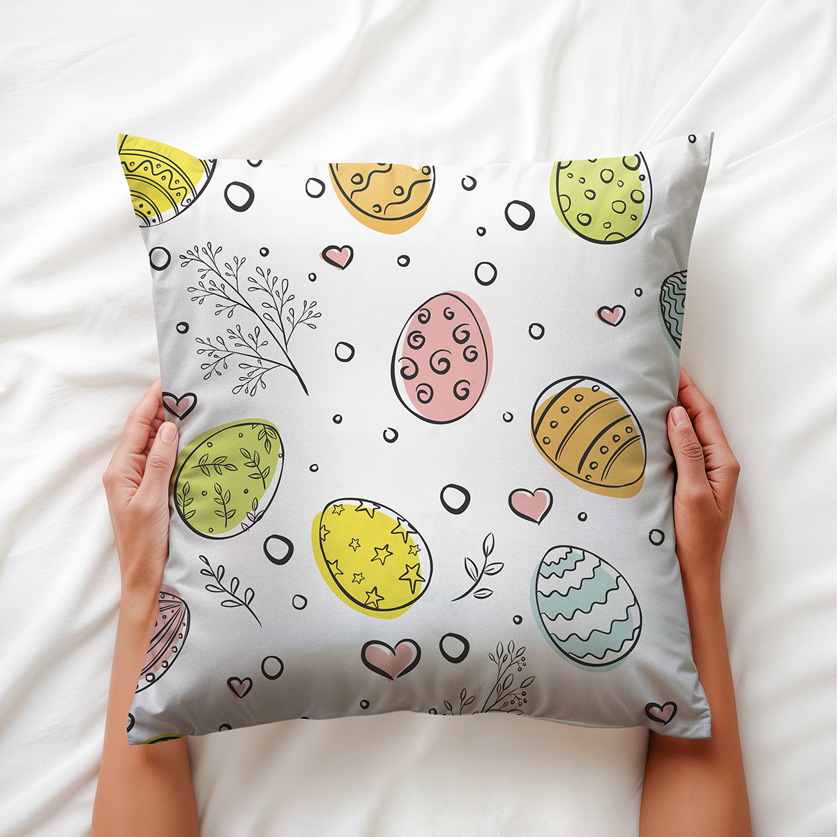 Ręce trzymające poduszkę z wiosennym motywem widziane z góry