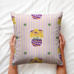 Ręce trzymające poduszkę z motywem bratków w doniczce na jasnym tle