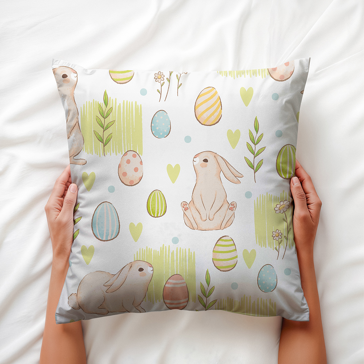 widok z góry pokazujący dłonie trzymające poduszkę z pastelowym motywem