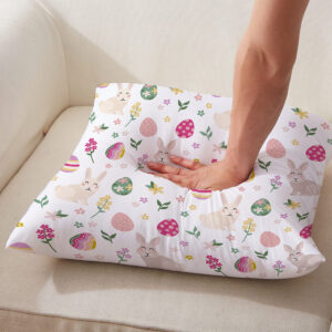 Osoba naciskająca poduszkę z wiosennym wzorem króliczków i pisanek, zbliżenie na materiał