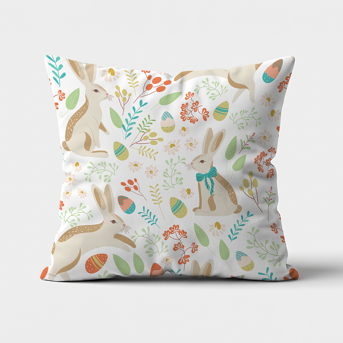 Poduszka dekoracyjna z ilustracją zajęcy i pisanek na białym tle — ujęcie frontalne