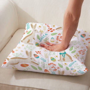 Zbliżenie na poduszkę z ręką naciskającą środek, pokazujące miękkość i detal nadruku