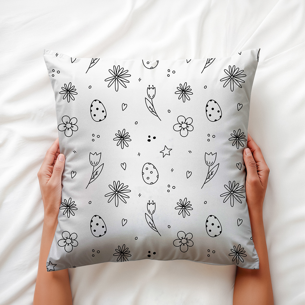 Górne ujęcie poduszki trzymanej dłońmi pokazujące rozłożenie motywu i kompozycję wzoru