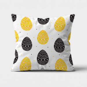 Główne ujęcie dekoracyjnej poduszki z wzorem żółtych i czarnych pisanek na białym tle
