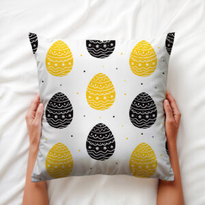 Poduszka trzymana w dłoniach, widoczny motyw pisanek i miękka tkanina
