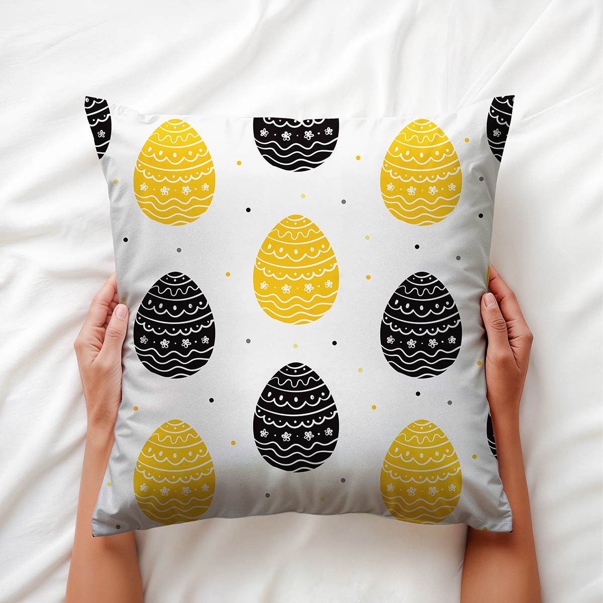 Poduszka trzymana w dłoniach, widoczny motyw pisanek i miękka tkanina