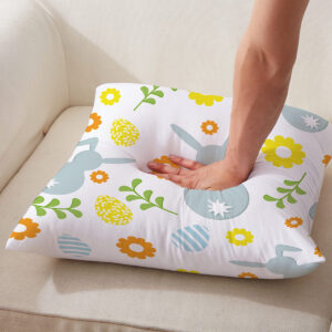 Ręka naciskająca poduszkę, pokazująca miękkość i detal nadruku z zajączkami