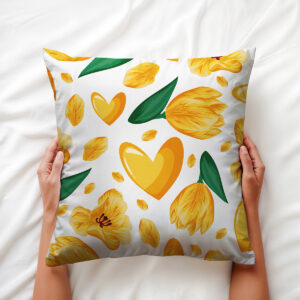 Poduszka trzymana w dłoniach, widoczny wzór tulipanów i serc