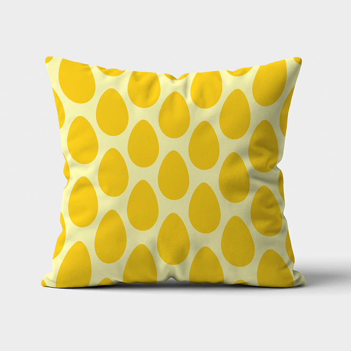 Przód poduszki z wzorem żółtych pisanek na kremowym tle, ujęcie produktowe