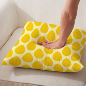 Zbliżenie na dłoni naciskającej poduszkę, pokazujące miękkość wypełnienia i strukturę materiału