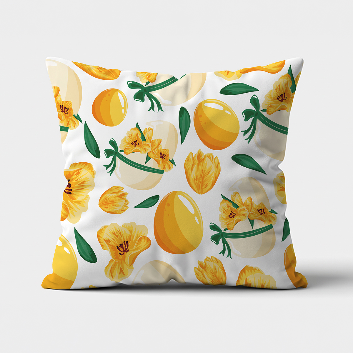 Główne ujęcie poduszki z żółtymi pisankami i żółtymi kwiatami na białym tle