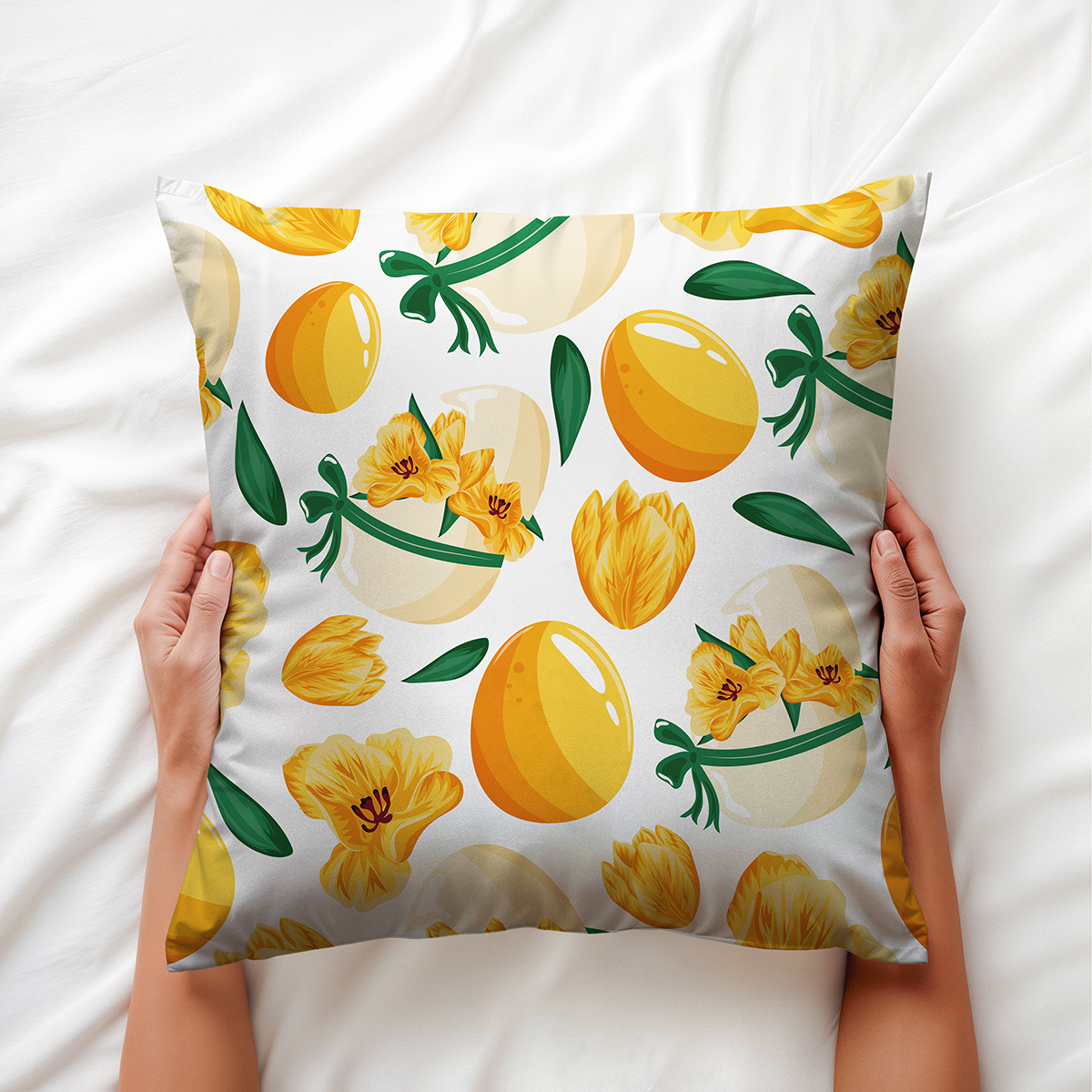 Widok poduszki trzymanej w dłoniach, wzór z jajkami i zielonymi listkami