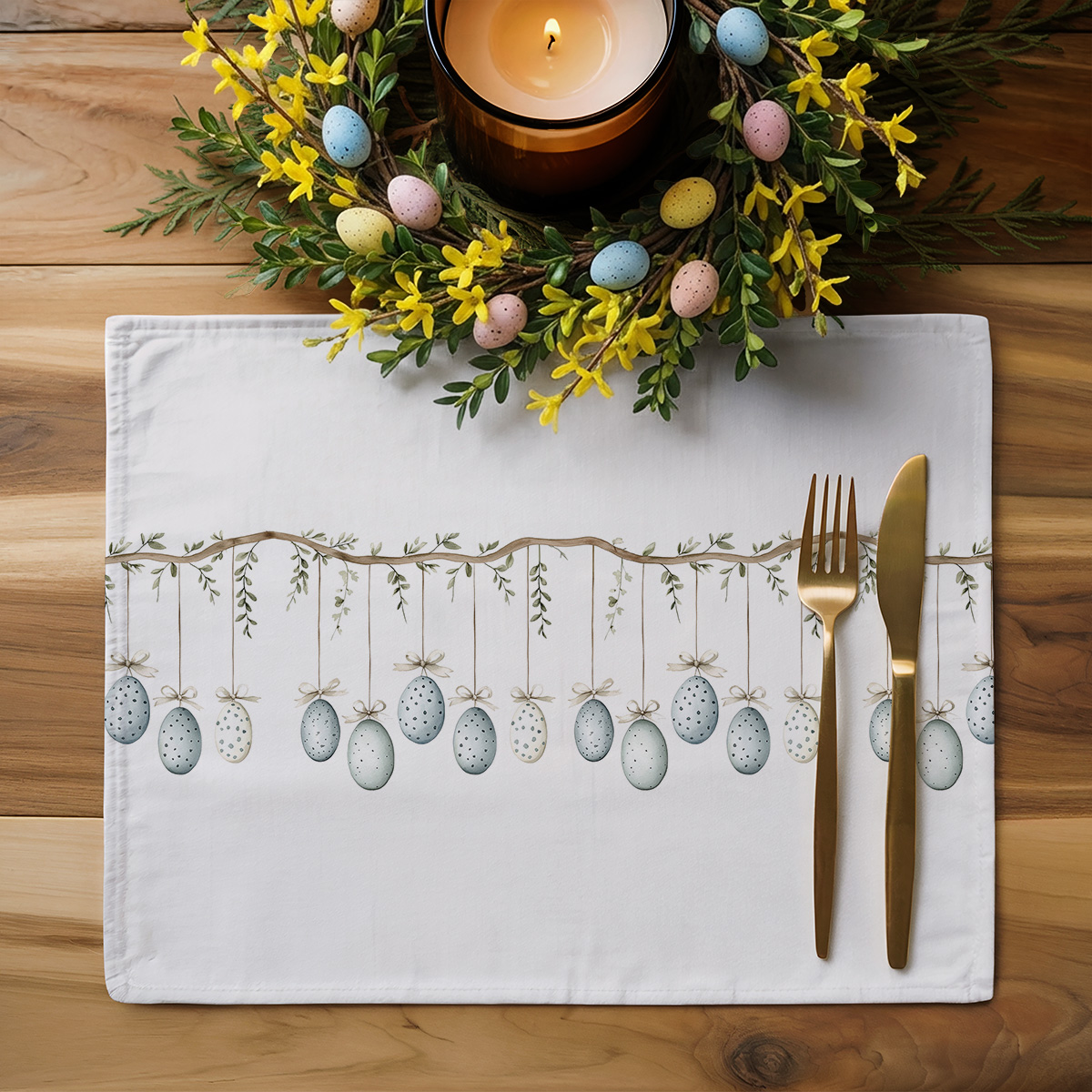 Aranżacja stołu: podkładka z motywem jajek przy dekoracyjnym wianku i sztućcach