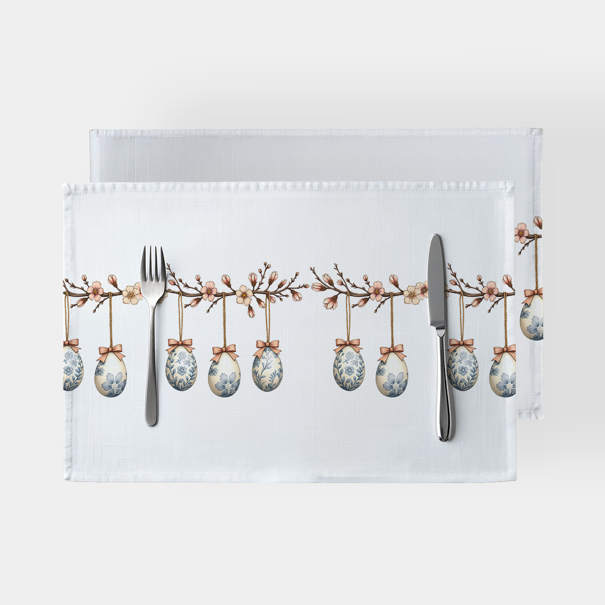 biała podkładka z wzorem wiszących pisanek zawieszonych na gałązkach, ujęcie główne