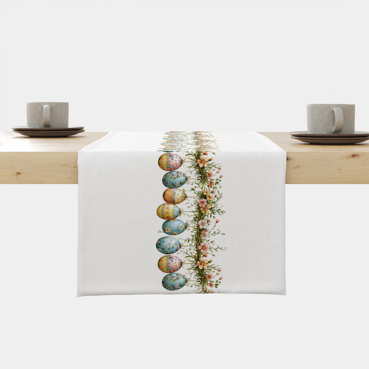 Bieżnik z rzędem malowanych pisanek i kwiatową girlandą na jasnym tle, ujęcie frontalne