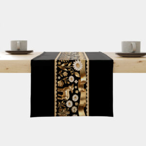 czarny bieżnik z centralnym złotym pasem ozdobionym barankami i wstęgą na drewnianym stole