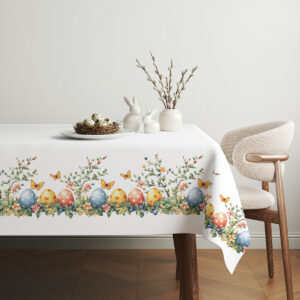 aranżacja stołu z obrusem, wiklinowy koszyk z pisankami i wiosenne dekoracje