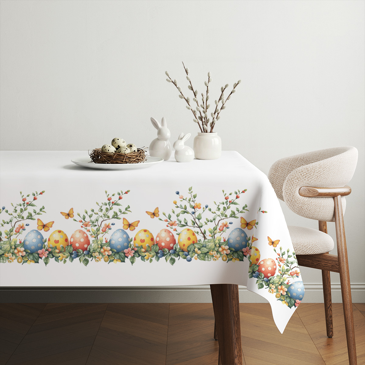 aranżacja stołu z obrusem, wiklinowy koszyk z pisankami i wiosenne dekoracje