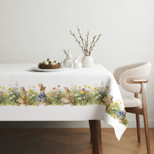 Aranżacja stołu z prostą zastawą i koszyczkiem jajek na tle świątecznego obrusu