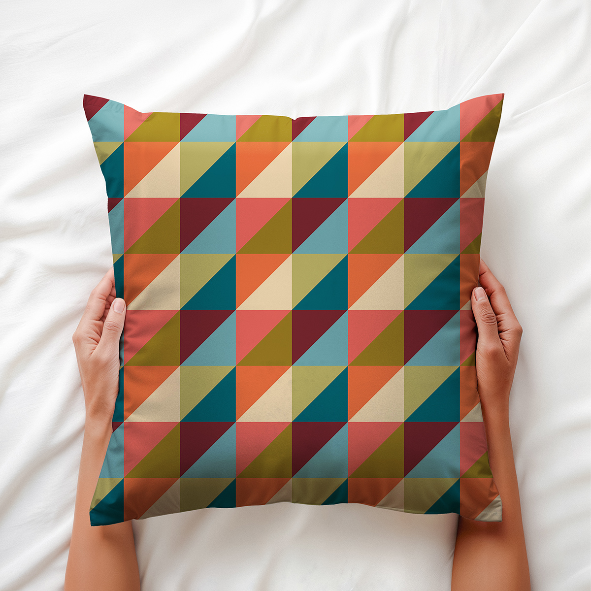 Zbliżenie na poduszkę trzymaną w dłoniach pokazujące kolorowe trójkąty i fakturę tkaniny