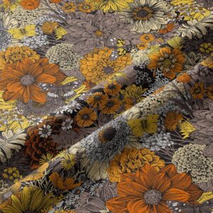 Zbliżenie na tkaninę pokazujące szczegóły rysunkowych kwiatów, motyli i ciepłą paletę kolorów