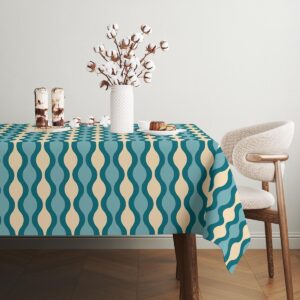 Wazon z gałązkami bawełny ustawiony na obrusu z falistym wzorem w naturalnym świetle