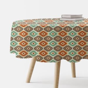 okrągły obrus na drewnianym stole z książkami, widoczny aztecki wzór miętowo-terakotowy
