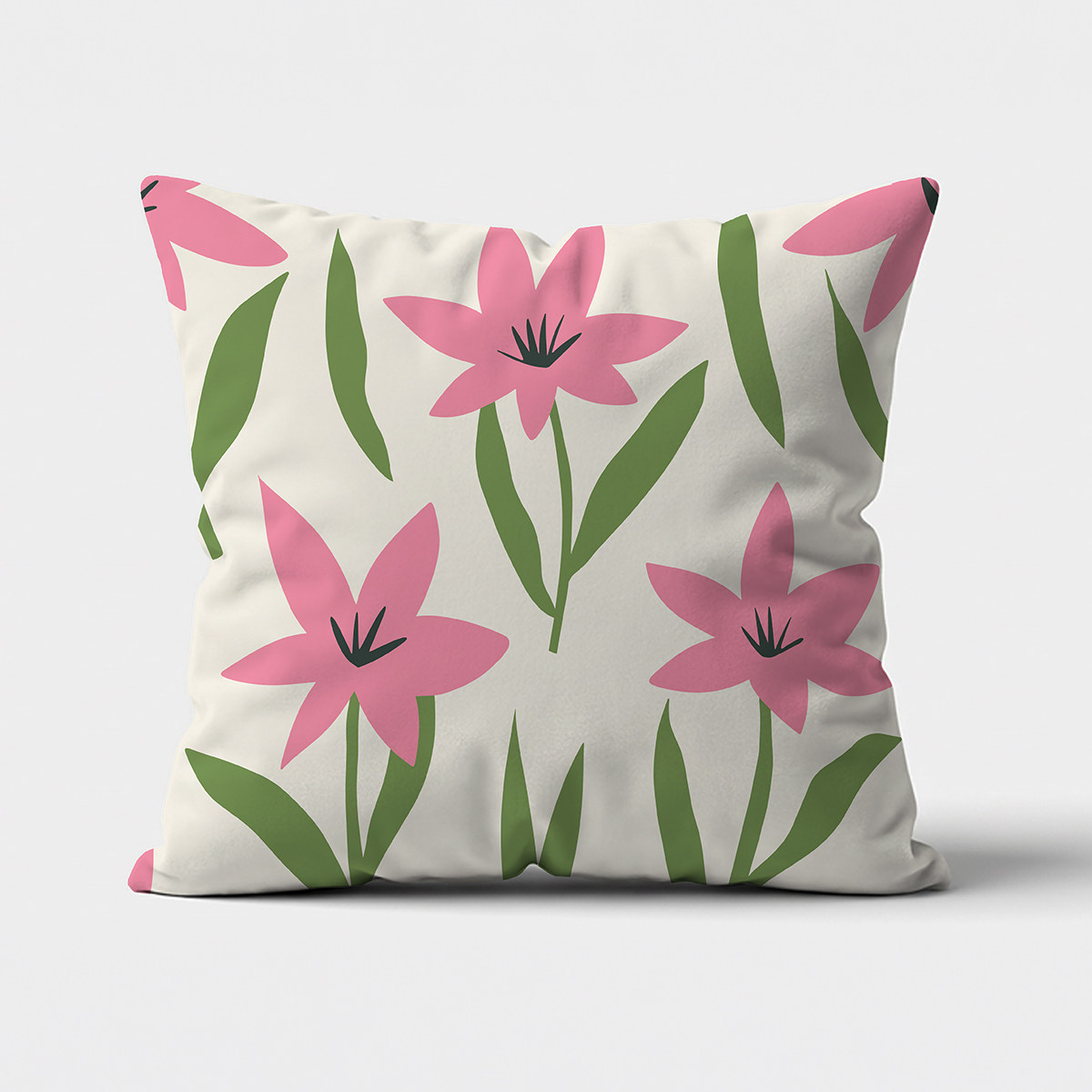 Poduszka na jasnym tle z przodu, widoczny motyw różowych kwiatów i zielonych liści