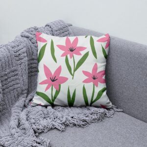 Poduszka ustawiona na szarej sofie obok pledu, dekoracyjny akcent w wnętrzu