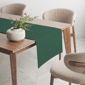 zielony bieżnik na stole z wazonem i krzesłami w tle