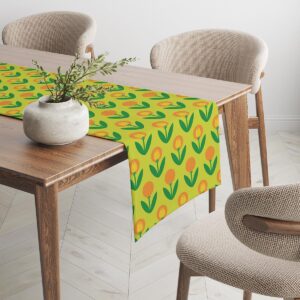 Bieżnik z motywem tulipanów na drewnianym stole obok beżowych krzeseł i dekoracji