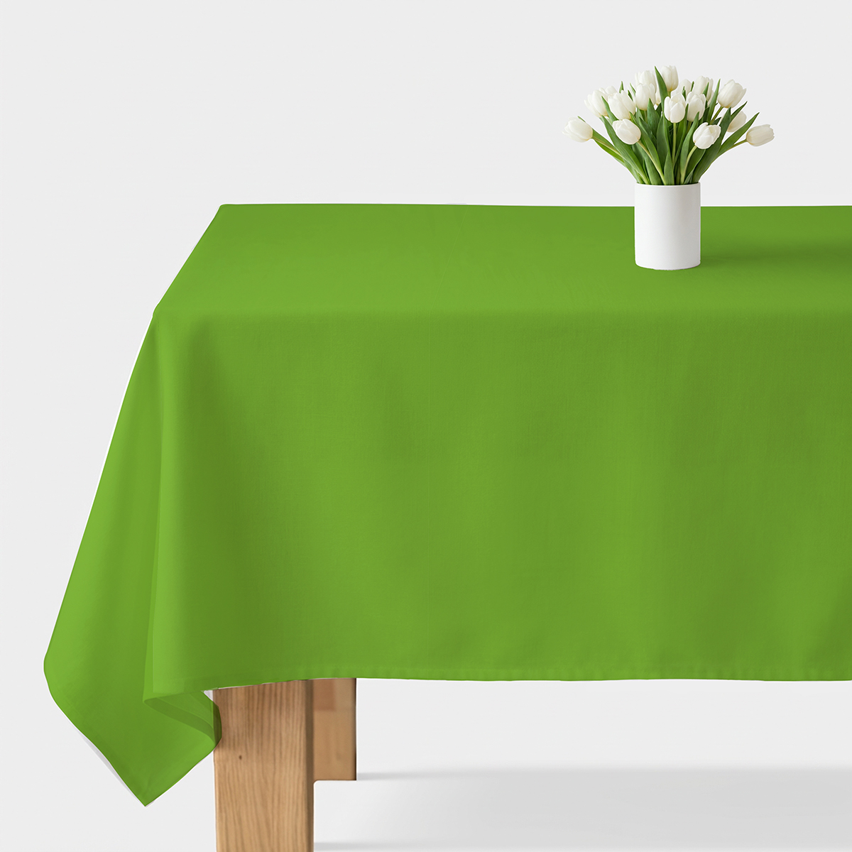 gładki zielony obrus rozłożony na stole z białym wazonem z tulipanami