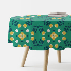 Okrągły stół przykryty zielonym obrusem z żółtymi kwiatami widok z boku