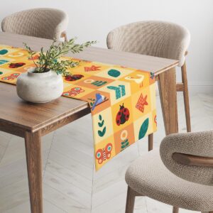 Bieżnik na stole jadalnym, ujęcie narożnika z powtarzającym się wzorem zwierzątek i roślin