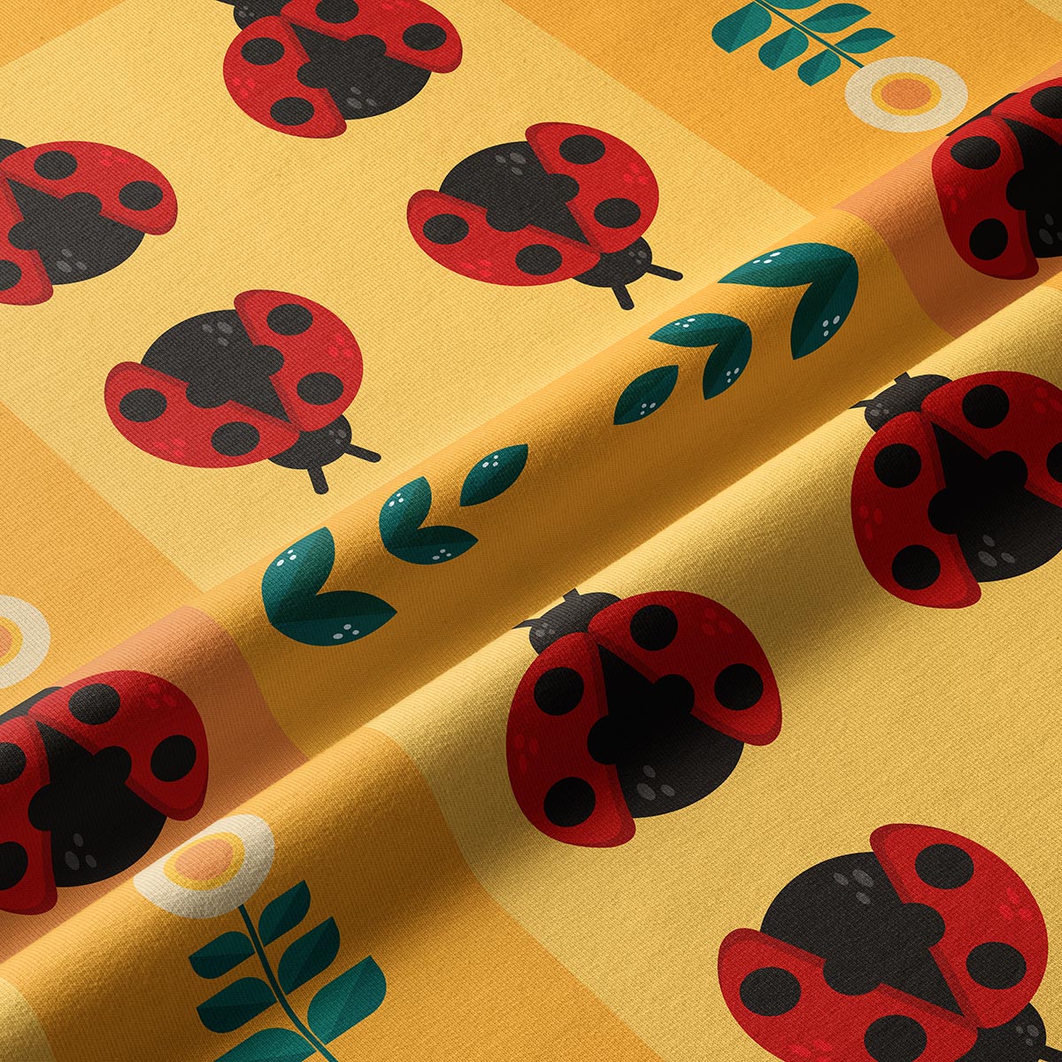 Zbliżenie tkaniny z czerwonymi biedronkami, zielonymi listkami i fakturą materiału