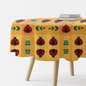 okrągły obrus na stole z wzorem czerwonych biedronek i kwiatów w kratce