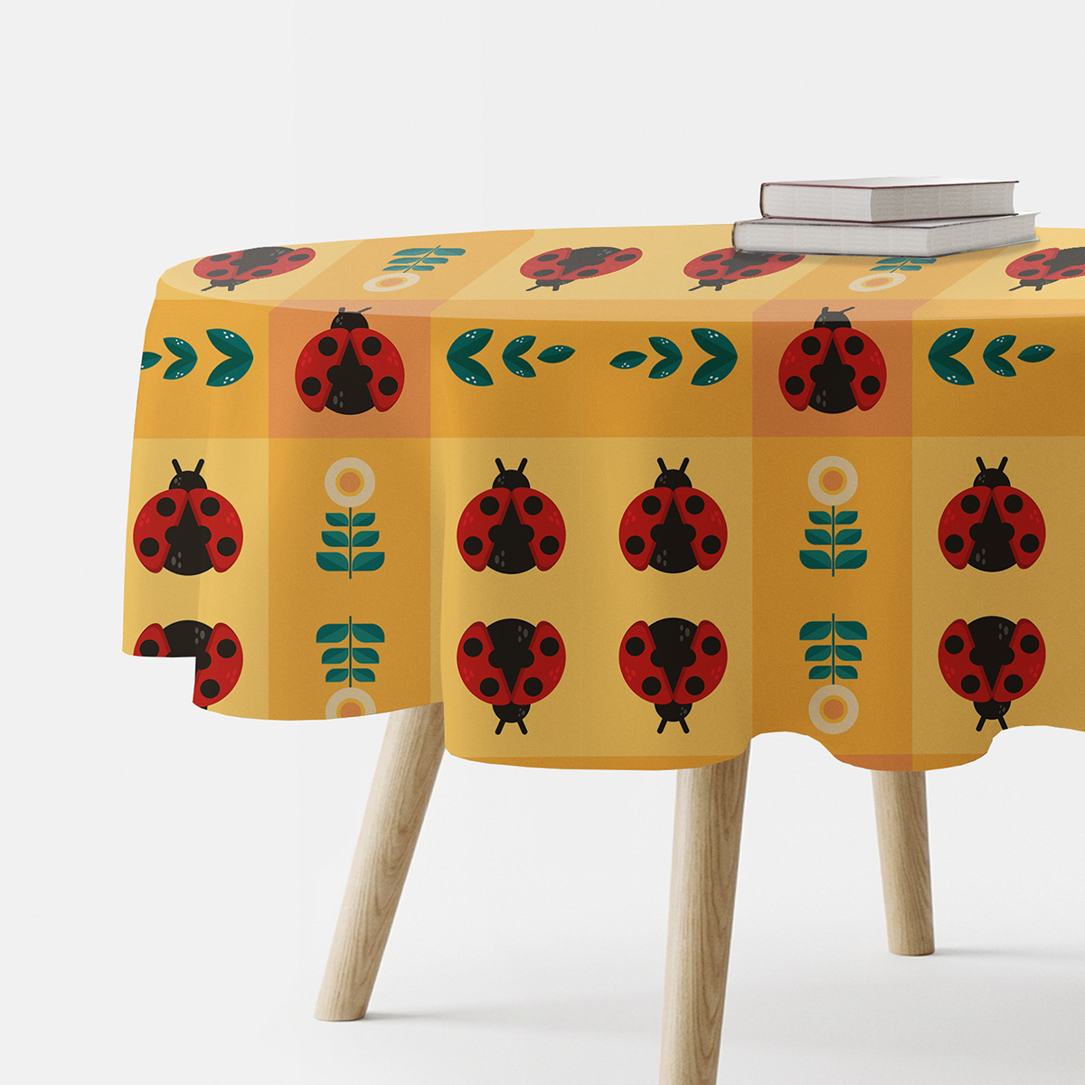 okrągły obrus na stole z wzorem czerwonych biedronek i kwiatów w kratce