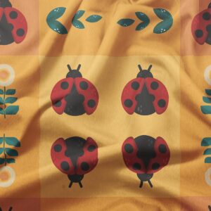 zbliżenie na tkaninę z motywem biedronek i zielonych listków