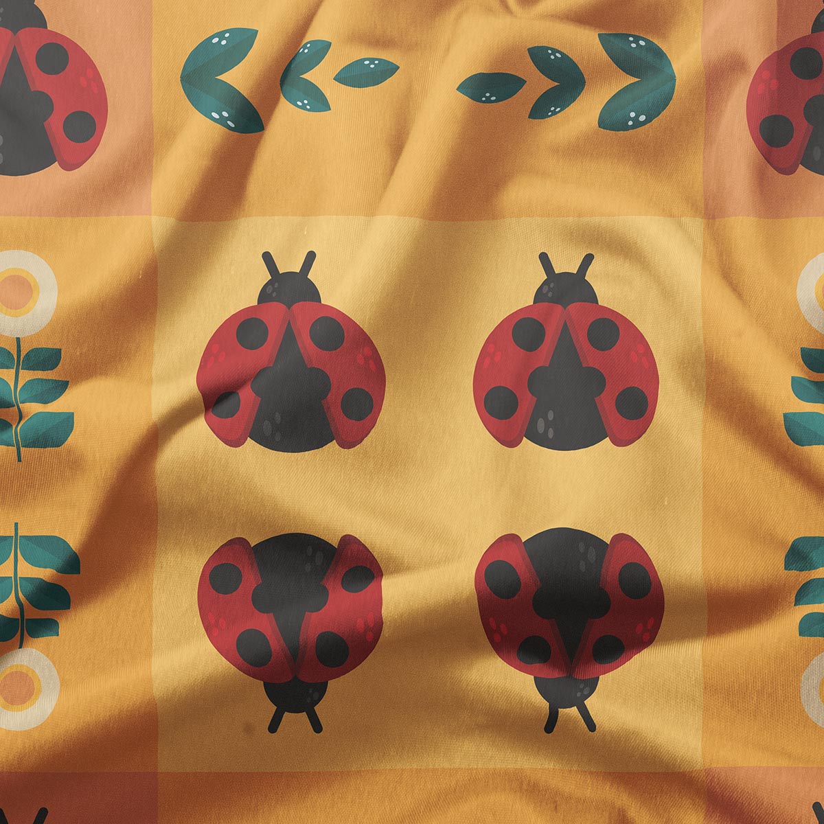 zbliżenie na tkaninę z motywem biedronek i zielonych listków