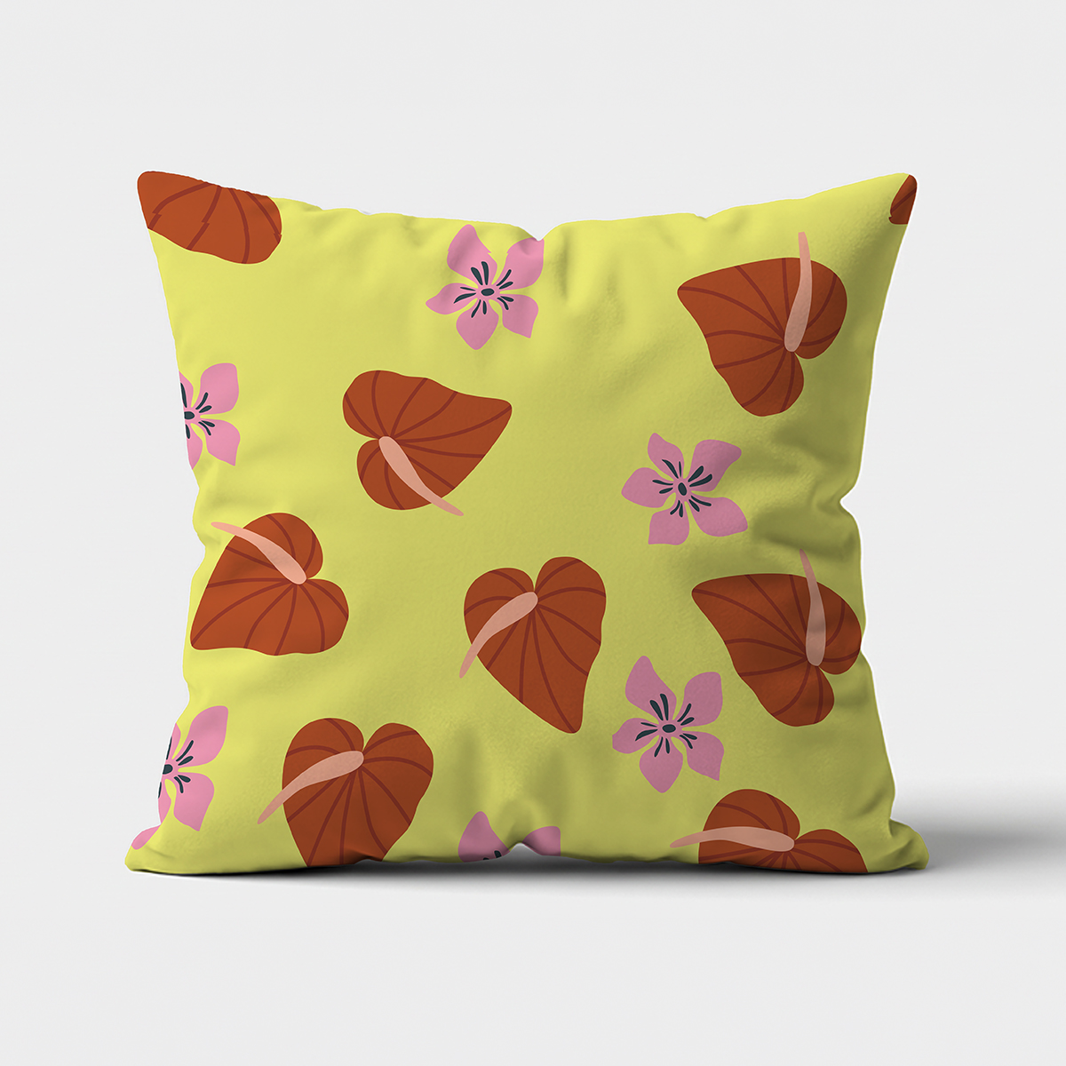 Kwadratowa poduszka na jasnym tle z limonkowym tłem, brązowe liście w kształcie serc i różowe kwiaty