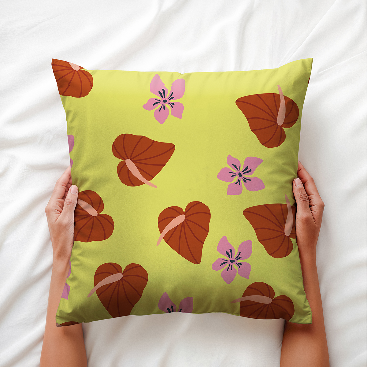 Ujęcie z bliska pokazujące poduszkę trzymaną w dłoniach i wyraźny roślinny wzór