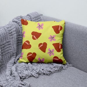 Poduszka ułożona na szarej sofie obok pledu jako dekoracyjny akcent wnętrza