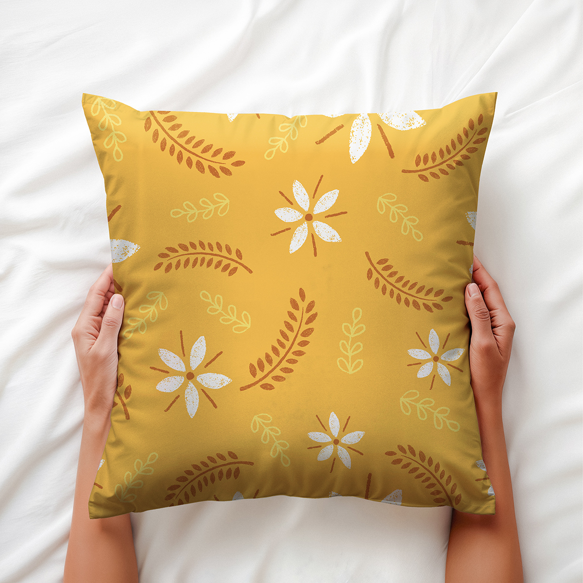 Ujęcie z bliska, osoba trzyma poduszkę w rękach; widoczne detale nadruku i faktura tkaniny