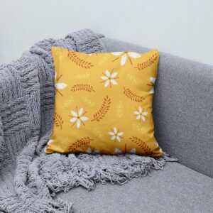 Poduszka ułożona na szarej sofie obok pledu, aranżacja pokazująca jak wzór pasuje do wnętrza