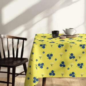 Stół przykryty obrusem z powtarzalnym, owocowym deseniem w przytulnym wnętrzu