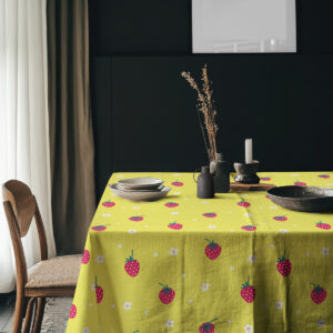 Nakryty stół z obrusem w truskawki i ceramicznymi naczyniami w aranżacji